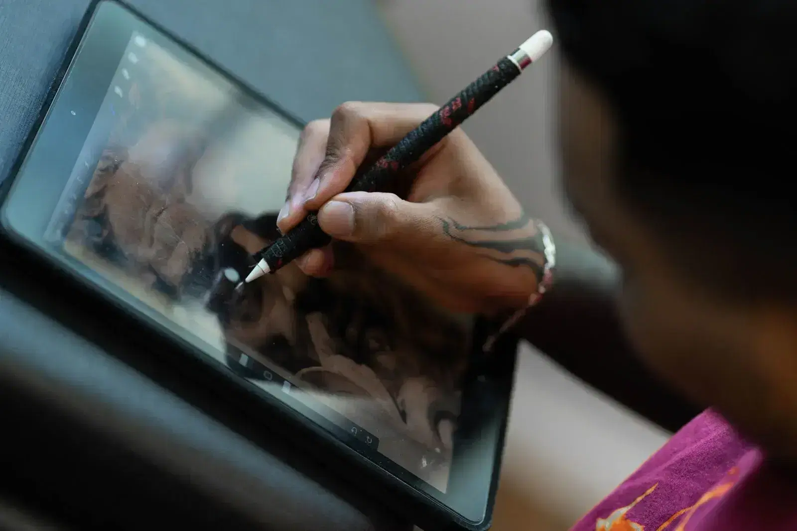 A closeup on a Mighty Koi artist's hand working on an Ipad